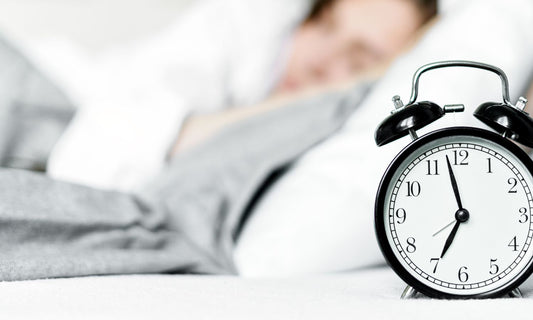 person sleeping and clock in foreground