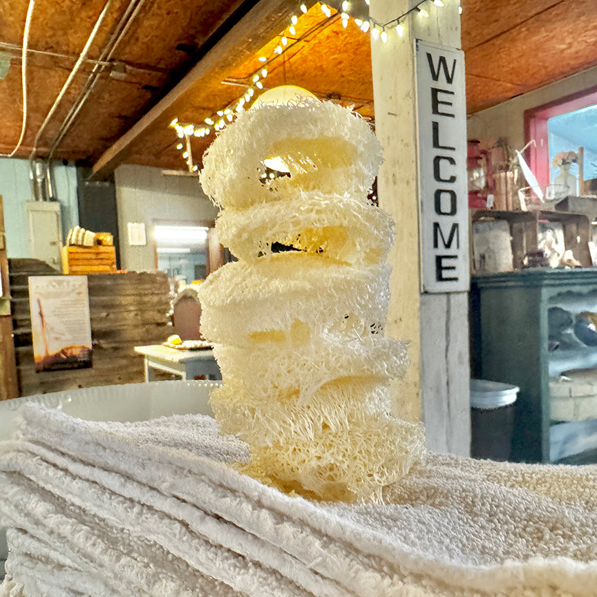 Stack of white towels with a decorative item in a rustic indoor setting.