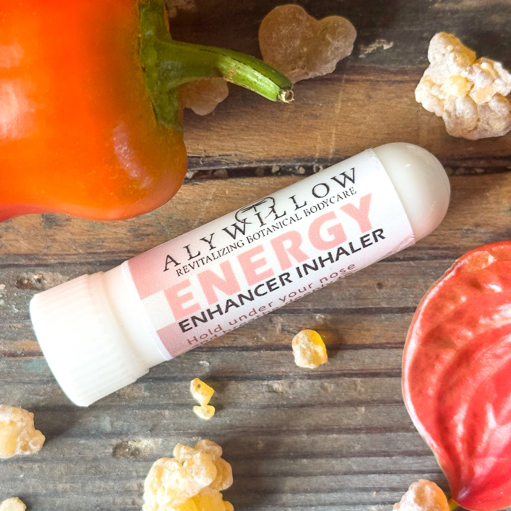 Alyellow Energy Enhancer Inhaler on a wooden surface with peppers and popcorn.